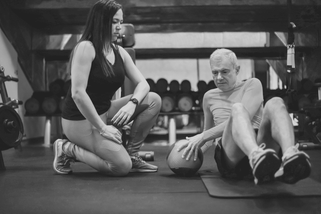 A young woman and an old man preparing for exercise inside the gym